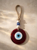 Amulette Nazar OREPLINE — œil de verre bordeaux avec perles blanches et bleues sur cordon en jute